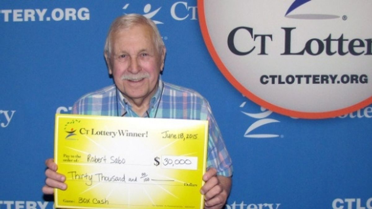 Bob Sabo posa con su premio de la lotería