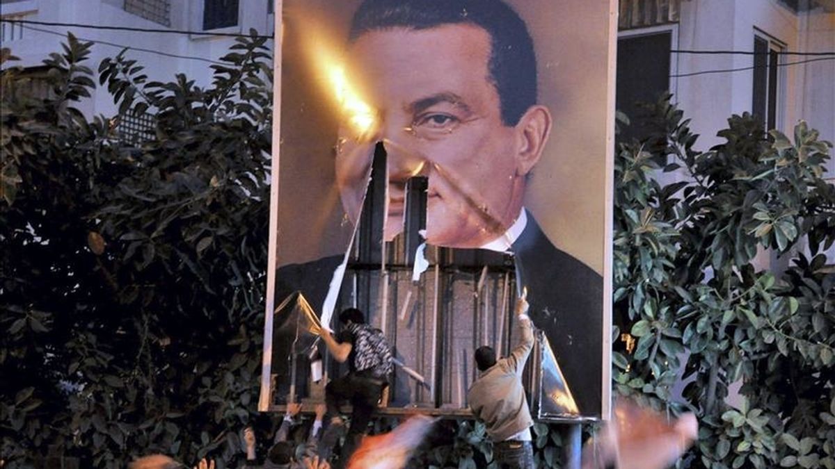 En la imagen, un grupo de manifestantes retirando un cartel con la imagen del ex presidente egipcio Hosni Mubarak durante una protesta en Alejandría, Egipto. EFE/Archivo
