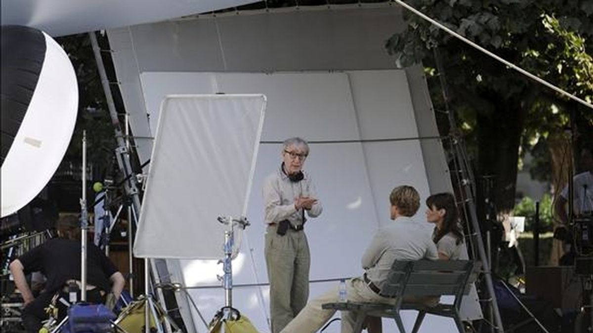 El director estadounidense Woody Allen (c) habla con la primera dama francesa Carla Bruni-Sarkozy (d) y el actor estadounidense Owen Wilson (2-d) en la plaza Juan XXIII, detrás de la catedral de Notre Dame, durante el rodaje de la más reciente película de su película, "Media noche en París". EFE