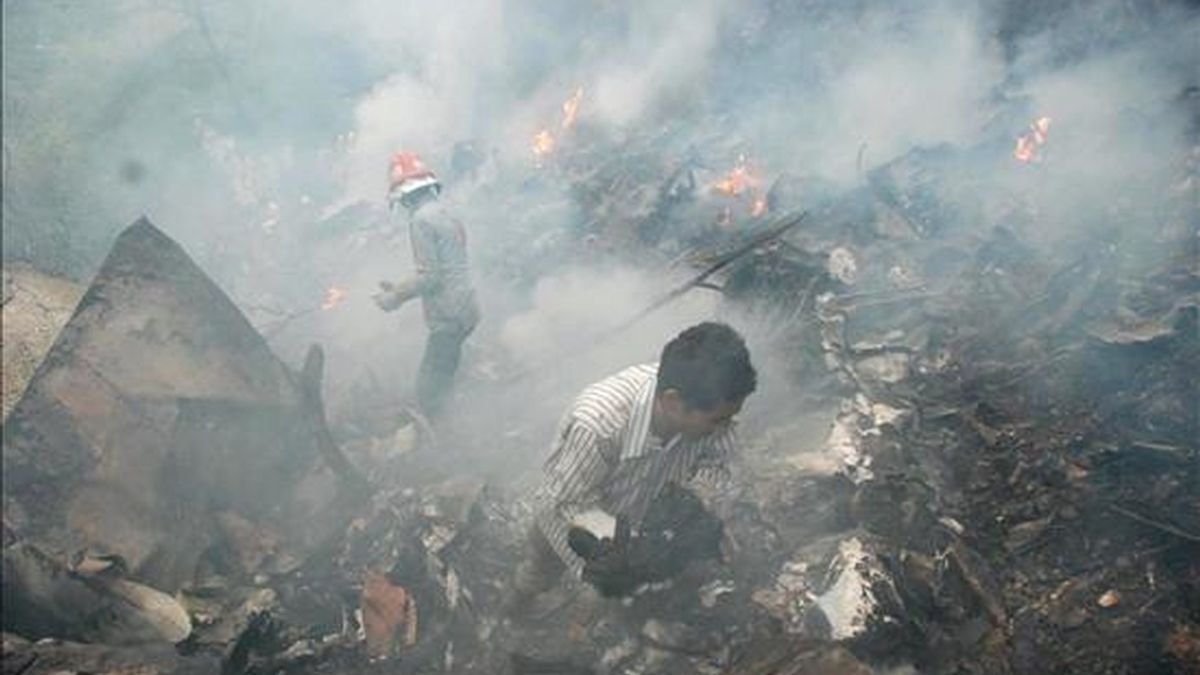 Empleados de los servicios de rescate trabajando en la zona en la que se estrelló este miércoles un avión de la compañía aérea privada Air Blue en Islamabad. Los 152 ocupantes del avión han fallecido. EFE