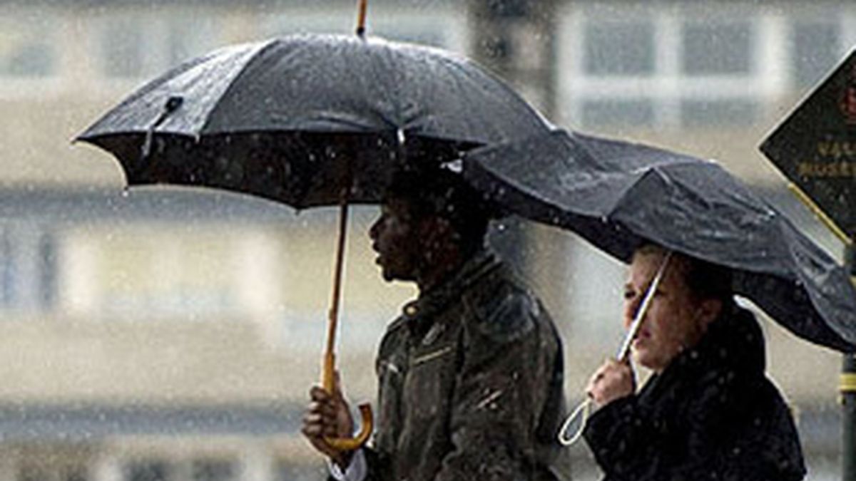 Imagen de archivo de dos personas protegiéndose de la lluvia en Alicante. Foto: EFE