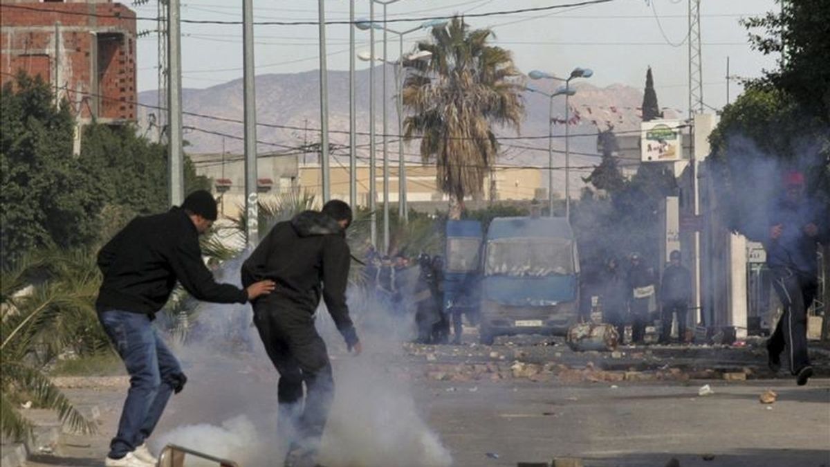 Jóvenes intentan esquivar las bombas de gases lacrimógenos lanzadas por policías durante unos violentos enfrentamientos vividos al término de una protesta contra el paro y la exclusión social, en Regueb, Túnez. EFE Jóvenes intentan esquivar las bombas de gases lacrimógenos lanzadas por policías durante unos violentos enfrentamientos vividos al término de una protesta contra el paro y la exclusión social, en Regueb, Túnez. EFE