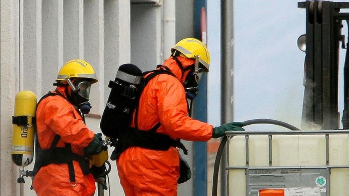 Bomberos con equipos especiales trabajan para controlar una fuga de vapor liberada en las instalaciones de una empresa textil de Tortosa (Tarragona), tras una pequeña explosión causada por una mezcla accidental de clorito de sosa y ácido clorhídrico en junio de 2006. EFE/Archivo