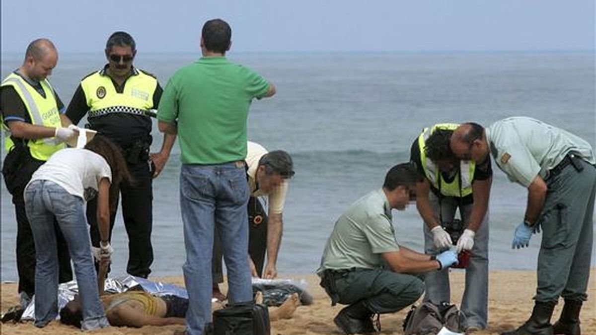 Agentes de la Guardia Civil y de la Policía Local de Barbate (Cádiz), en tareas de investigación en la playa barbateña de La Aceitera, donde dos hombres y dos mujeres de nacionalidad marroquí que habían viajado en una embarcación de madera fueron hallados muertos en la mañana de ayer. EFE