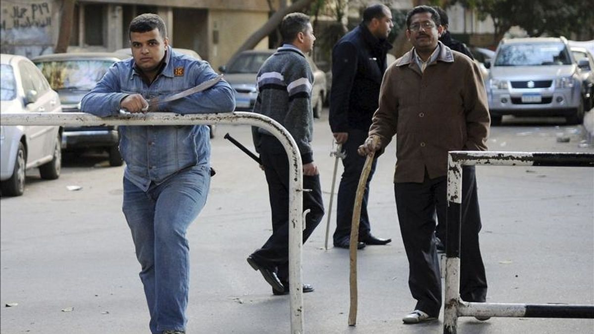 Un grupo de vecinos armados hace guardia a las puertas de sus hogares en El Cairo (Egipto) este  enero. Las autoridades egipcias decidieron cerrar hoy todas las oficinas en Egipto de la cadena de televisión qatarí Al Yazira, informó el mismo medio de comunicación. EFE