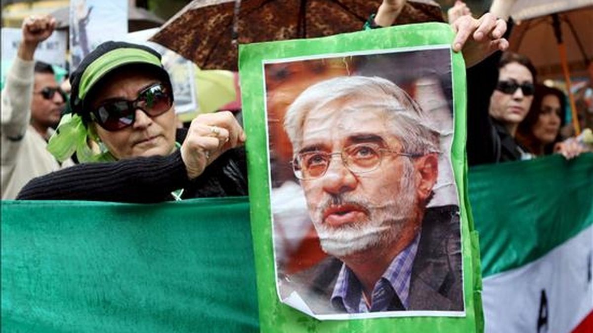 Una manifestante muestra un retrato del candidato a la presidencia iraní Mir Husein Musaví durante un acto de protesta por las presuntas irregularidades en las elecciones en Irán, en Hamburgo, Alemania, el pasado 20 de junio. EFE/Archivo