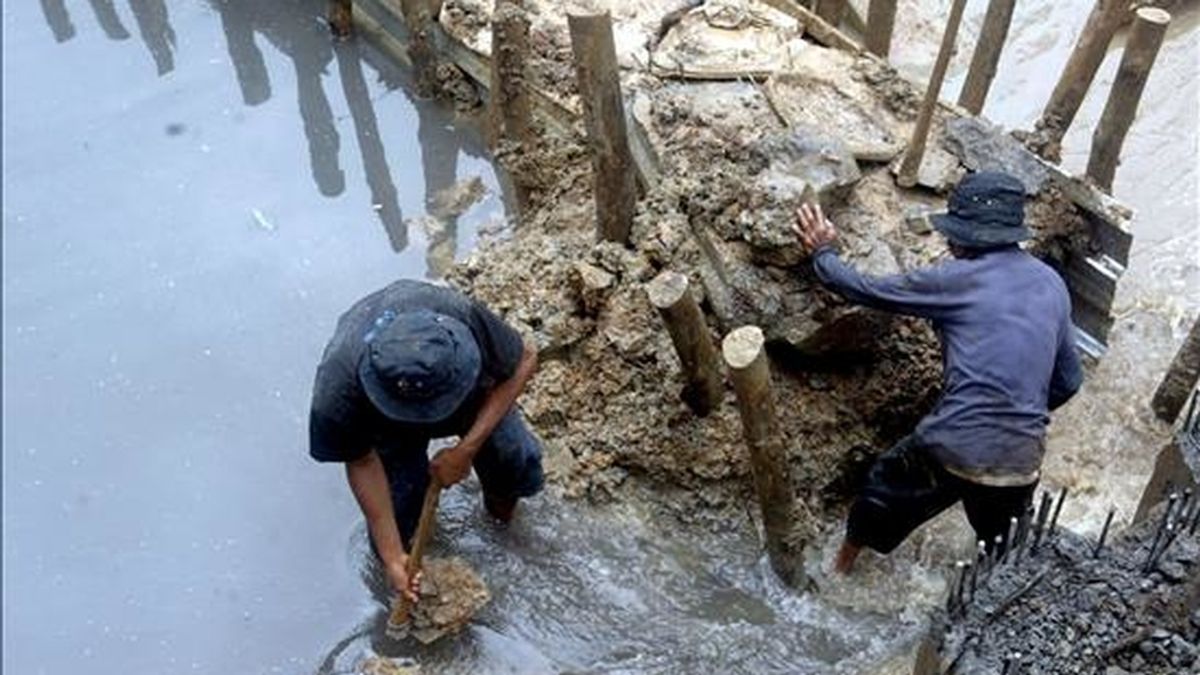Dos trabajadores indonesios construyen una presa en Yakarta. EFE/ARCHIVO