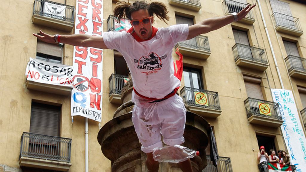 Un jóven juerguista salta desde la fuente de la Plaza Navarrería, una peligrosa costumbre en el inicio de los san fermines
