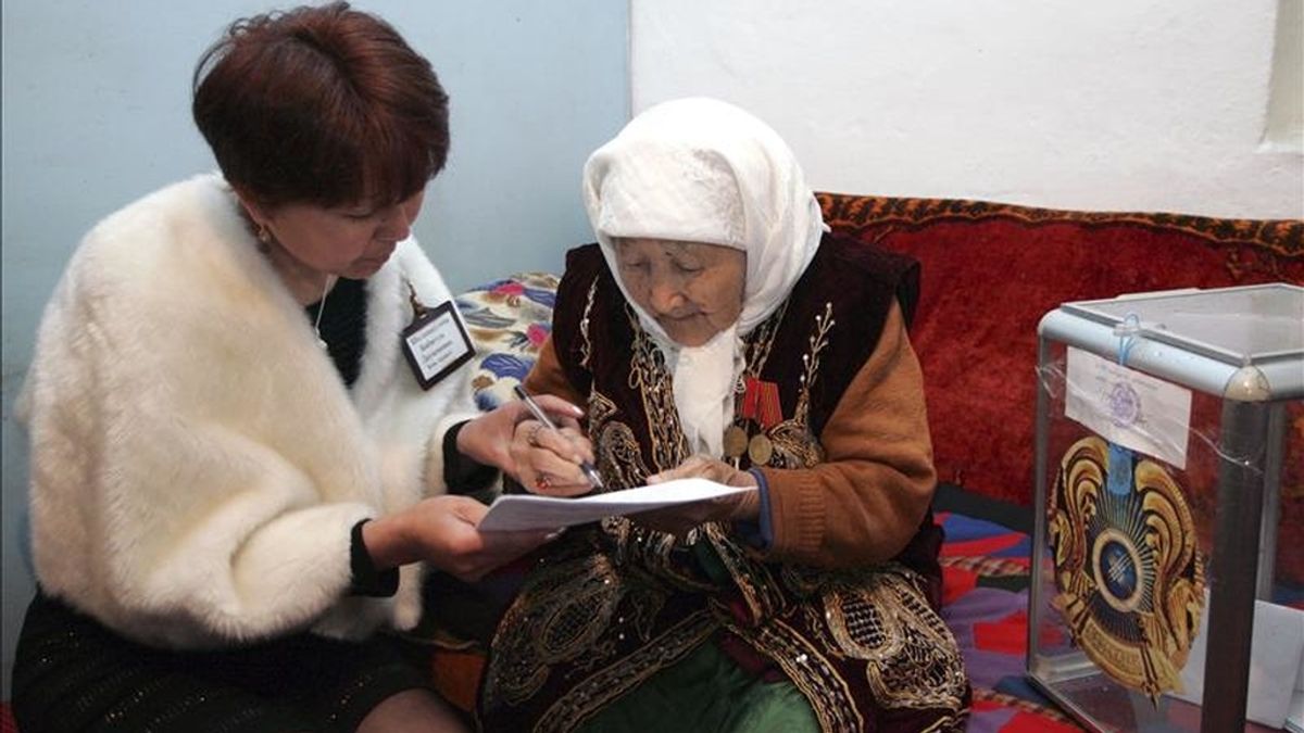 Una miembro de la mesa electoral ayuda a rellenar su papeleta a una anciana que votó en las elecciones presidenciales desde su propia casa, situada 80 km al sur de Almaty (Kazajistán), hoy, domingo 3 de abril de 2011. EFE