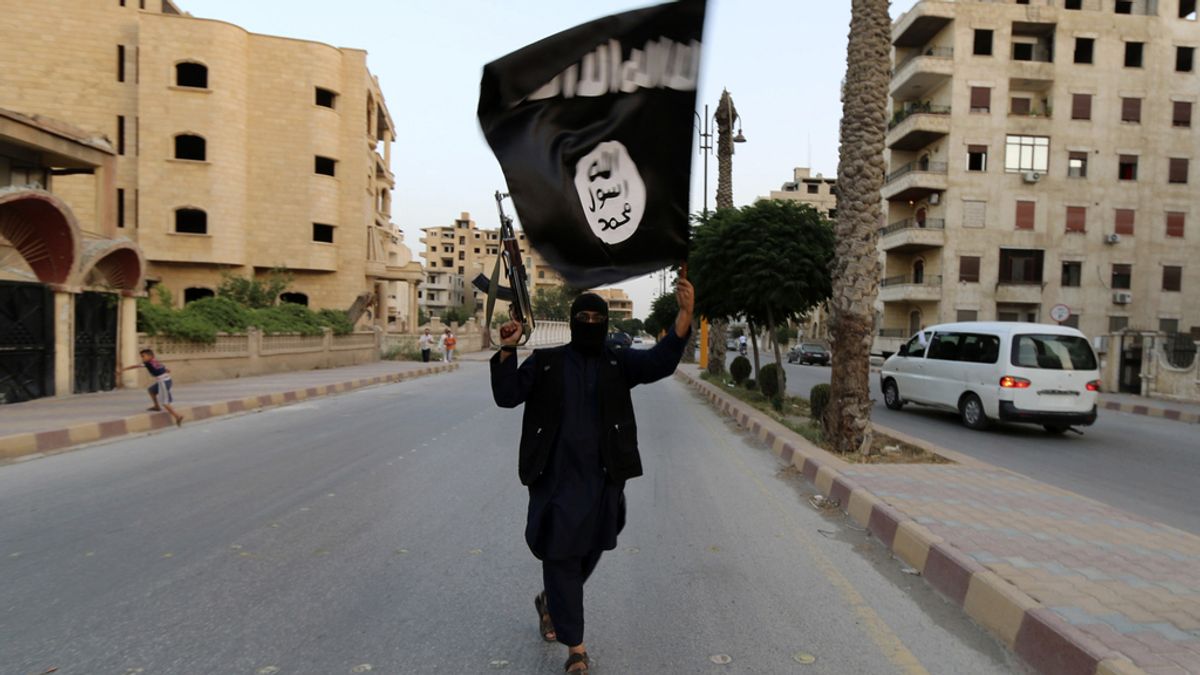 Un yihadista porta la bandera del Estado Islámico