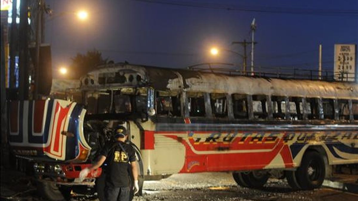 Un fiscal del Ministerio Público inspeccionan el autobús en el que impactó una bomba lanzada por desconocidos, en un sector del oeste de Ciudad de Guatemala. EFE