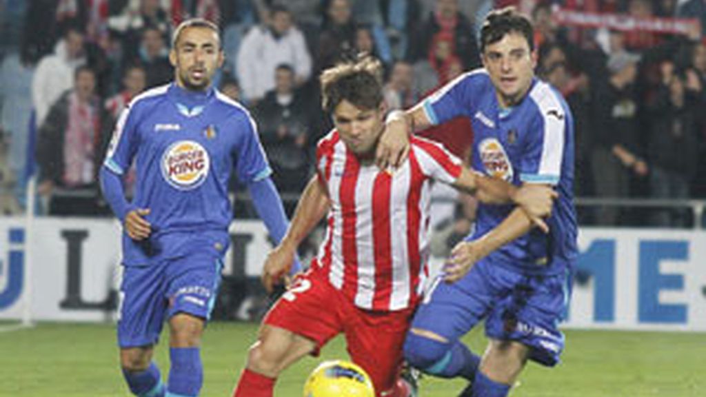El Getafe pelea un balón con Diego Ribas FOTO: EFE
