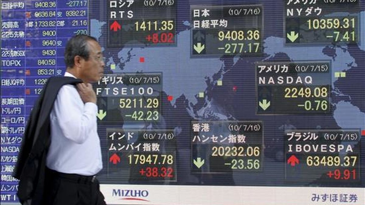 Un empresario pasa junto a una pantalla con los resultados de la Bolsa de Tokio (Japón). EFE/Archivo