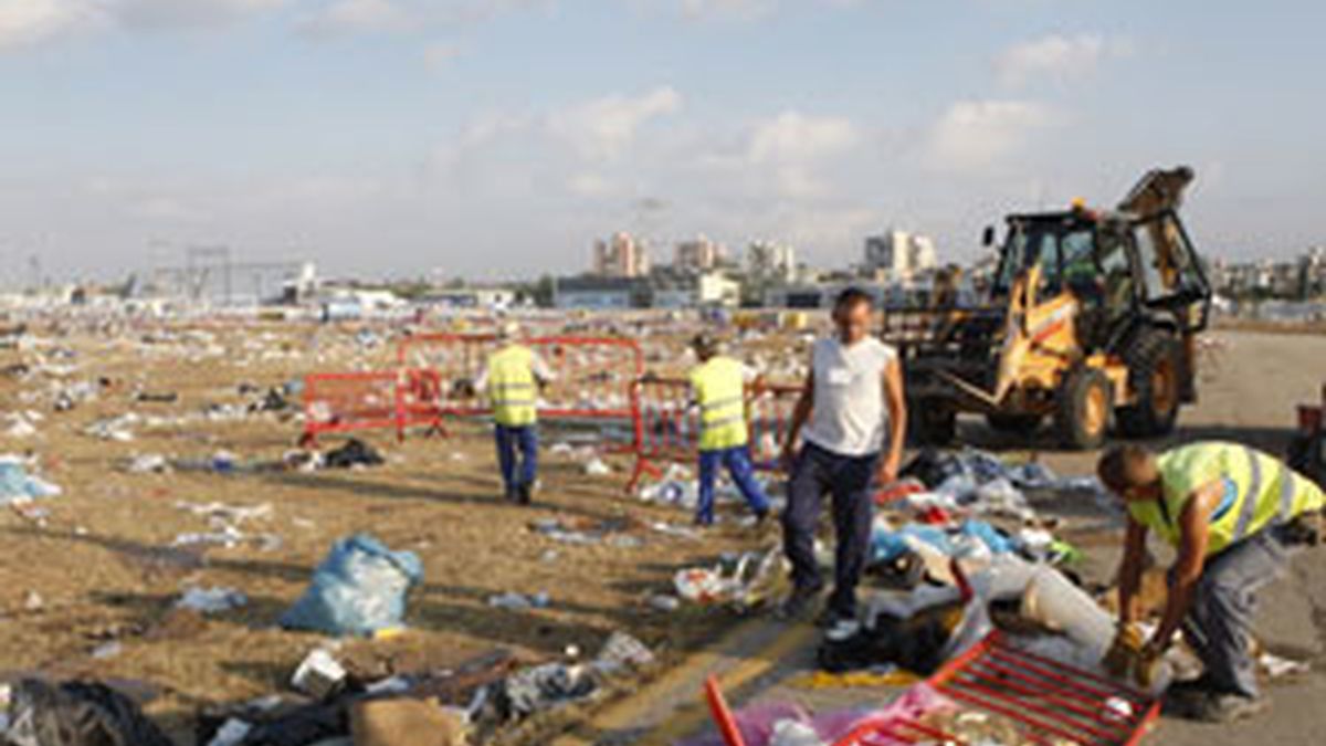 Personal de los servicios de limpieza recoge los restos y desperdicios que han quedado en el suelo de la Base Aérea de Cuatro Vientos de Madrid. Foto. EFE