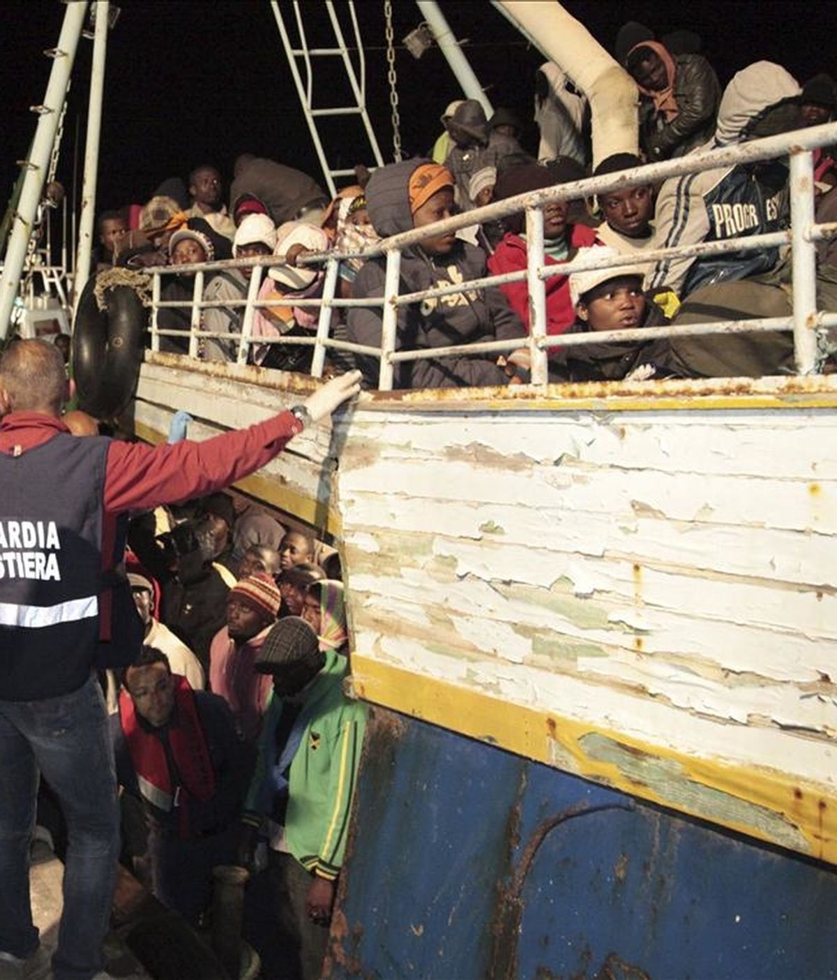 Guardias costeros ayudan a una embarcación recién llegada hoy de Libia en Lampedusa (Italia). Los 500 inmigrantes que viajaban en una barca procedente de Libia que encalló esta madrugada en unos escollos en las proximidades del puerto de la isla italiana de Lampedusa han sido rescatados, informaron hoy fuentes de la Capitanía de Puerto. EFE