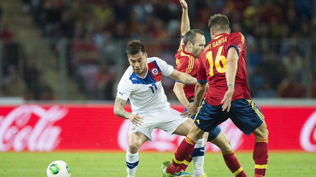Iniesta y Javier García pelean por el control del balón en el centro del campo