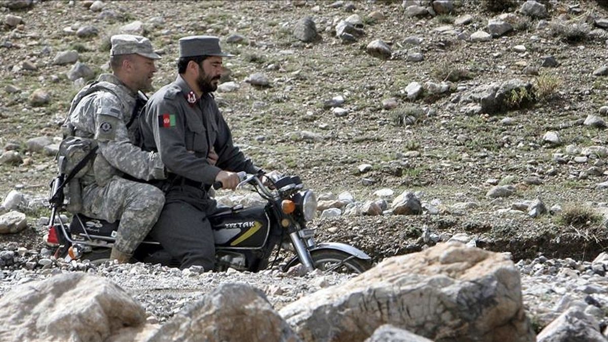 Un soldado estadounidense (izda) viaja en moto con un policía afgano (dcha) en el distrito de Jaghory en la provincia de Ghazni (Afganistán) este sábado. EFE