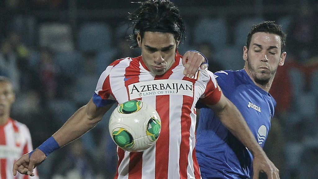 El delantero colombiano del Atlético de Madrid Radamel Falcao (i), controla el balón ante el delantero del Getafe Álvaro Vázquez