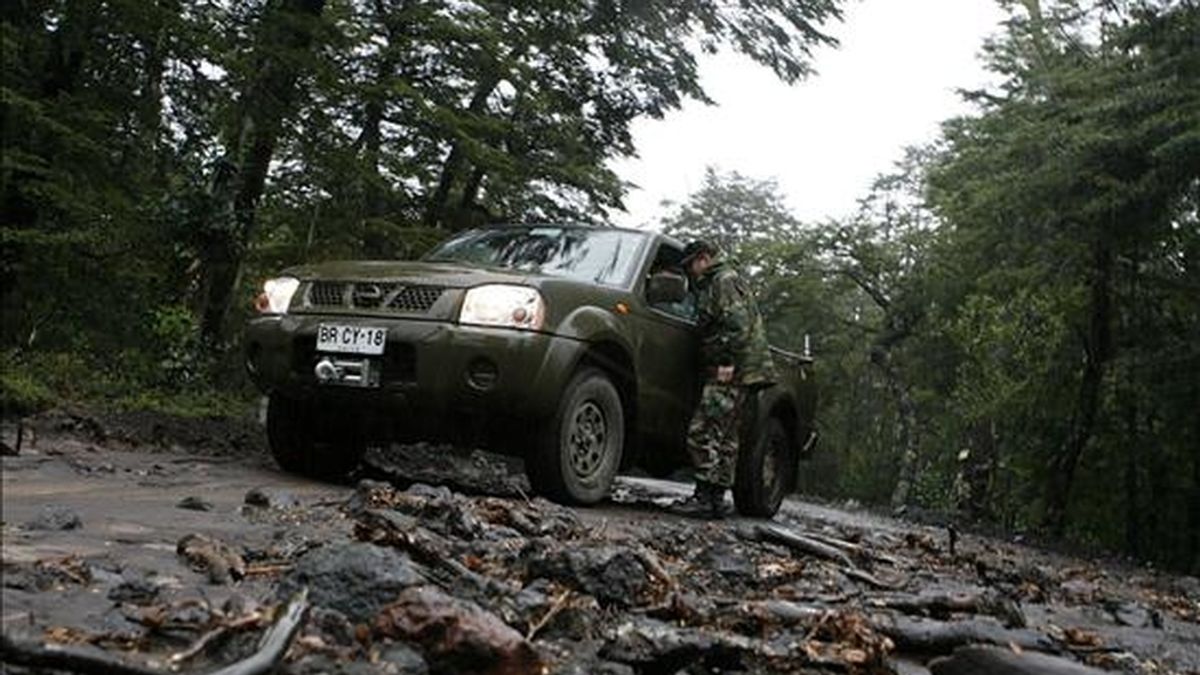 Un militar vigila el camino que conduce a la localidad de Captrén, deshabilitado a raíz del deshielo producido por la erupción del volcán chileno Llaima. EFE