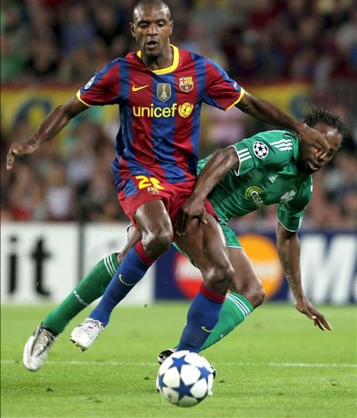 El jugador del FC Barcelona, Eric Abidal (i), pelea por el balón durante un partido. EFE/Archivo