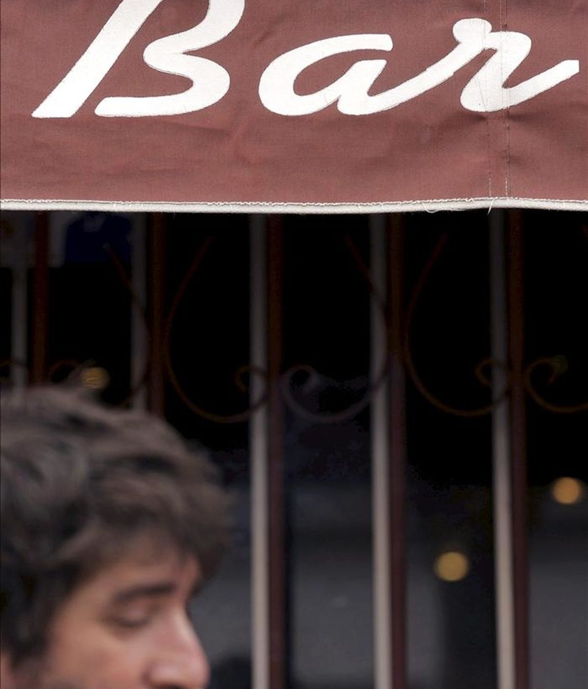Un hombre fuma en la puerta de un bar de Valladolid, en el primer día de entrada en vigor de la nueva Ley Antitabaco en España. EFE/Archivo