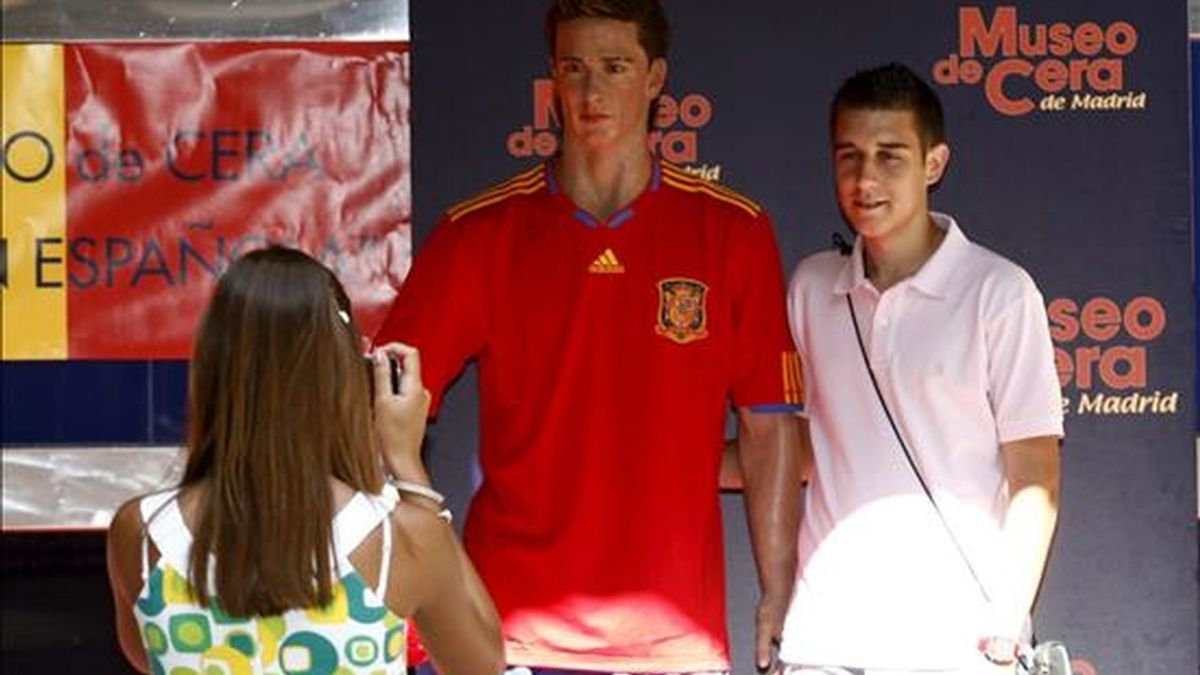 Un chico se fotografía junto a la figura de Torres que el Museo de Cera de Madrid ha sacado a la calle vestida con la camiseta roja de la Selección Española, en un gesto de apoyo al equipo para que gane mañana la final del campeonato mundial de Sudáfrica 2010. EFE