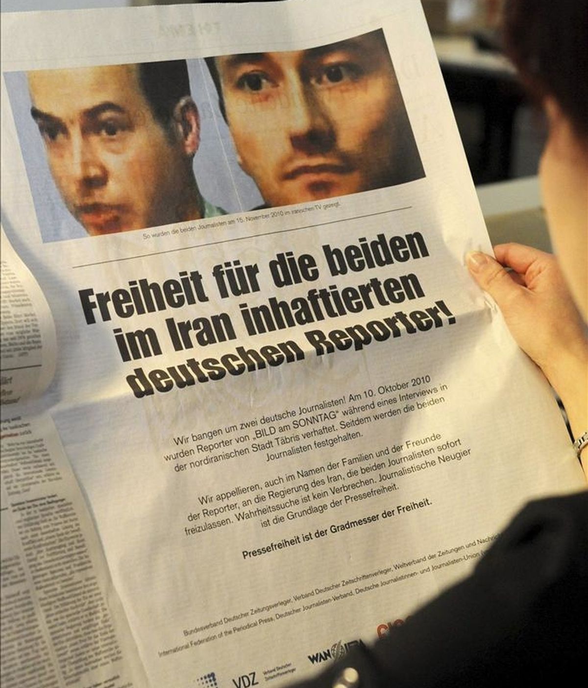 Una mujer lee un periódico en el que a toda página se reclama la puesta en libertad de dos periodistas alemanes, encarcelados en Irán. EFE/Archivo
