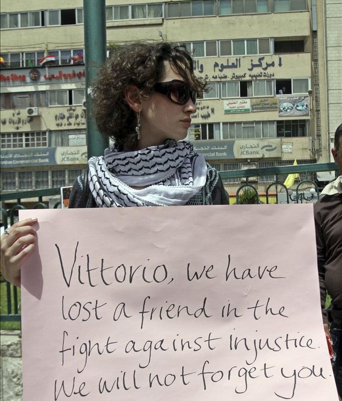 Una activista muestra una pancarta mientras participa en una protesta de repulsa al asesinato del joven activista italiano Vittorio Arrigoni, quien apareció muerto la madrugada del 14 de abril en Gaza tras ser secuestrado por un grupo extremista salafista, hoy sábado 16 de abril de 2011 en Naplusa, Cisjordania. EFE