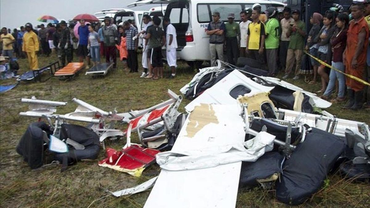 Una multitud observa los restos del avión estrellado hoy cerca del aeropuerto de Caimana (Indonesia). EFE