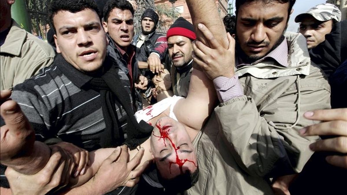 Manifestantes llevan en volandas a un joven que resulto herido durante los enfrentamientos entre partidarios del presidente egipcio, Hosni Mubarak, y opositores en la plaza Tahrir (de la Liberación), en El Cairo, Egipto, hoy, jueves, 3 de febrero de 2011. EFE Manifestantes llevan en volandas a un joven que resulto herido durante los enfrentamientos entre partidarios del presidente egipcio, Hosni Mubarak, y opositores en la plaza Tahrir (de la Liberación), en El Cairo, Egipto, hoy, jueves, 3 de febrero de 2011. EFE
