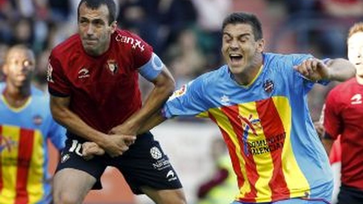 El centrocampista del CA Osasuna, Francisco Puñal (i), lucha la pelota aérea con el defensa del Levante UD, Sergio Ballesteros. EFE