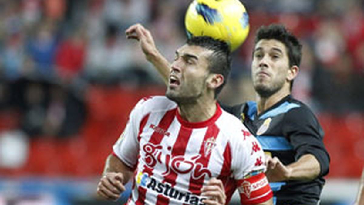 El delantero del Sporting de David Barral cabecea un balón ante el defensa del Espanyol Dídac Vila FOTO: EFE