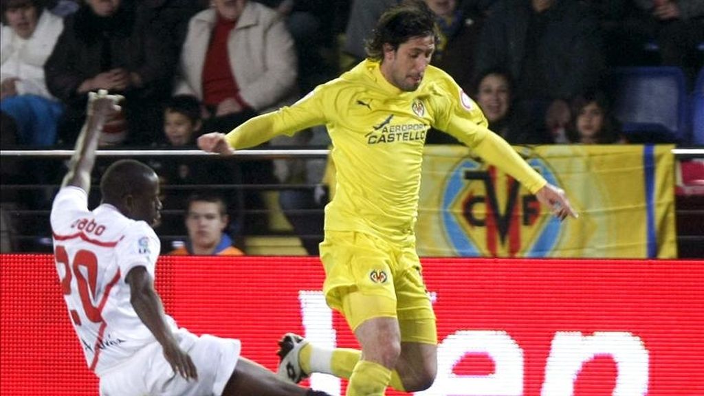 El defensa del Villarreal, Joan Capdevila (d) controla el balón ante el defensa senegalés del Sevilla Mouhamadou Dabo durante el partido de ida de cuartos de final de la Copa del Rey que ambos equipos disputaron el pasado miércoles en el estadio el Madrigal. EFE