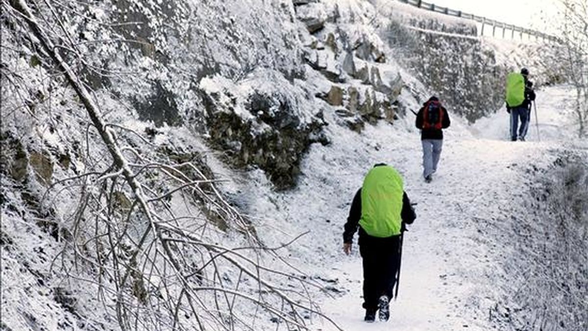 Varios peregrinos de Mallorca caminan por un paisaje completamente blanco, en el pueblo de Liñares, en O Cebreiro, debido a las intensas nevadas que se registran en la montaña de Lugo. EFE