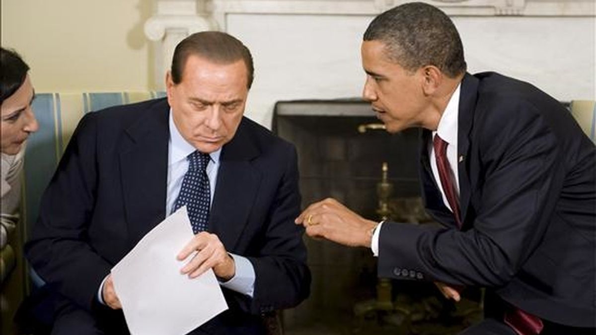 El presidente de EE.UU., Barack Obama (d), le habla a la traductora (i) del primer ministro de Italia, Silvio Berlusconi (c), durante su reunión en la Oficina Oval de la Casa Blanca en Washington DC (EE.UU.). EFE