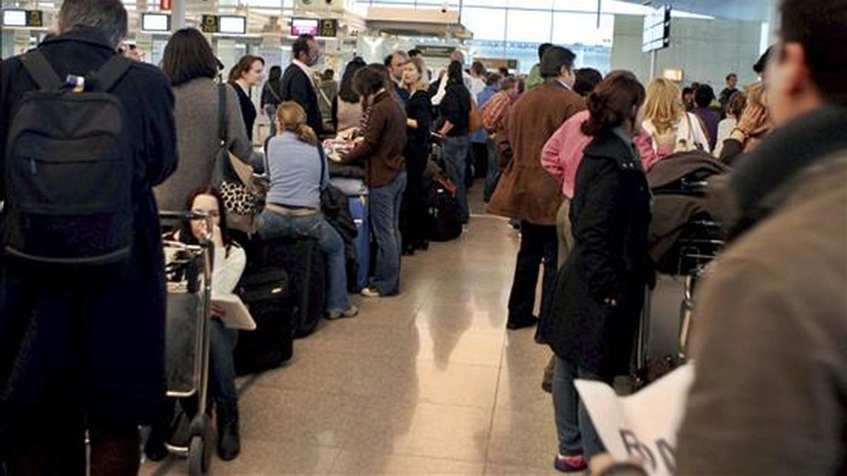 Varios pasajeros hacen cola frente a los mostradores de facturación en el aeropuerto del Prat de Llobregat (Barcelona) para volar, después de que el espacio aéreo español se cerrase ayer cuando los controladores abandonaron masivamente sus puestos de trabajo, y haya sido reabierto durante la tarde de hoy. EFE