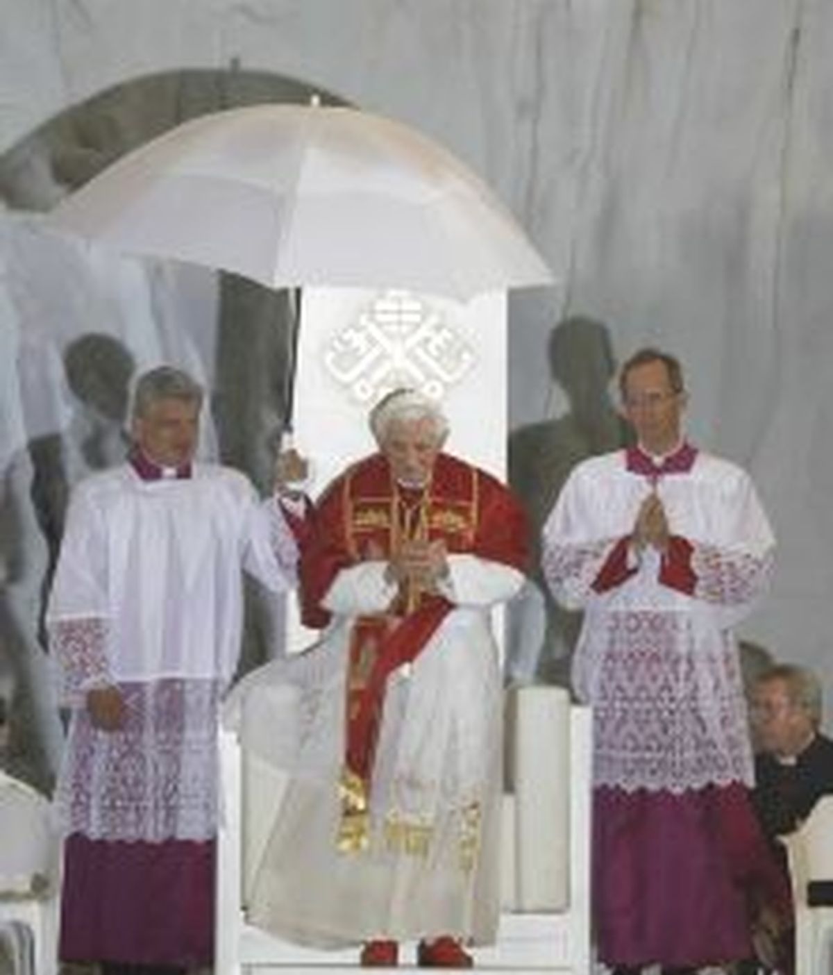 El papa Benedicto XVI es protegido de la lluvia caída durante la vigilia con los jóvenes. EFE