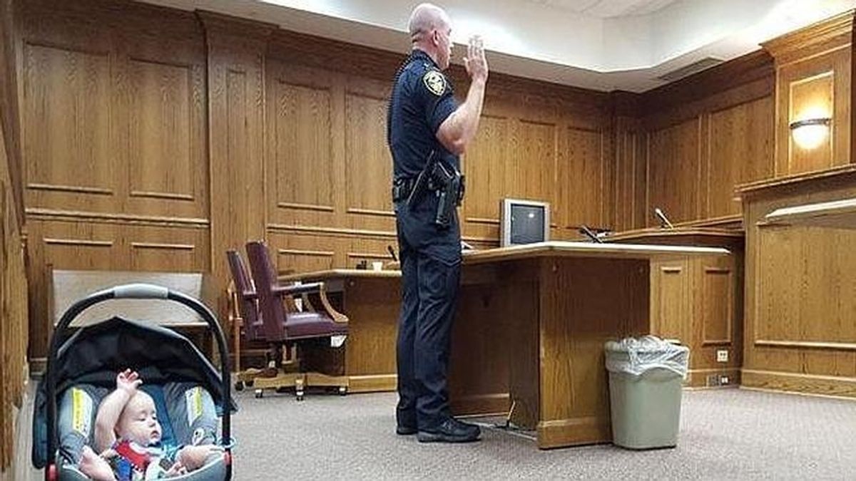 Un policía jura su cargo y su bebé le imita