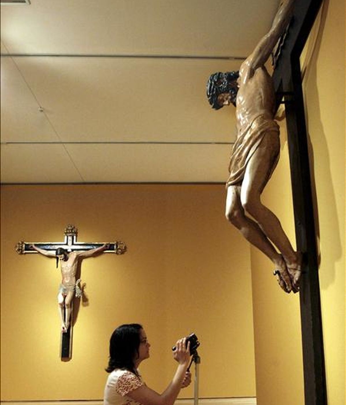 Una joven graba el "Cristo Crucificado", de Juan de Anchieta, con el "Cristo Crucificado", del escultor Damián Forment al fondo, obras que se exponen desde hoy en el Museo de Bellas Artes de Bilbao dentro de la muestra que recoge los fondos más significativos de la época renacentista del Museo de Zaragoza. EFE