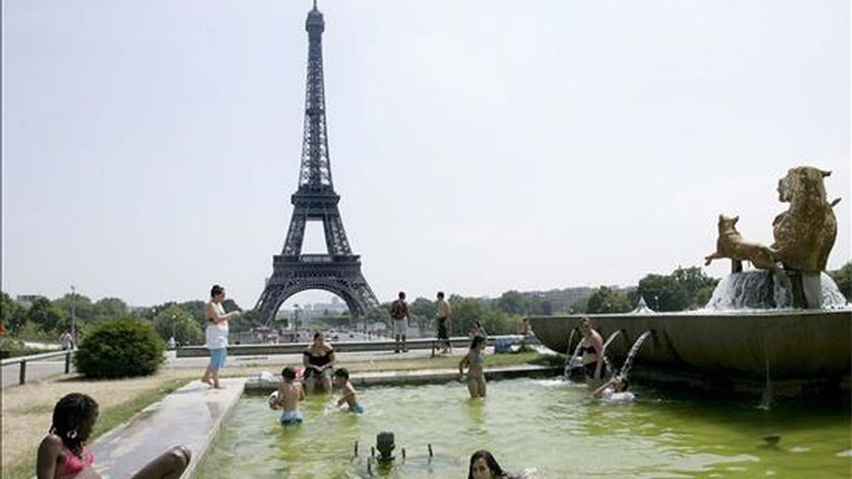 Un grupo de jóvenes se refresca en la fuente del Trocadero, frente a la Torre Eiffel, en París (Francia). EFE/Archivo