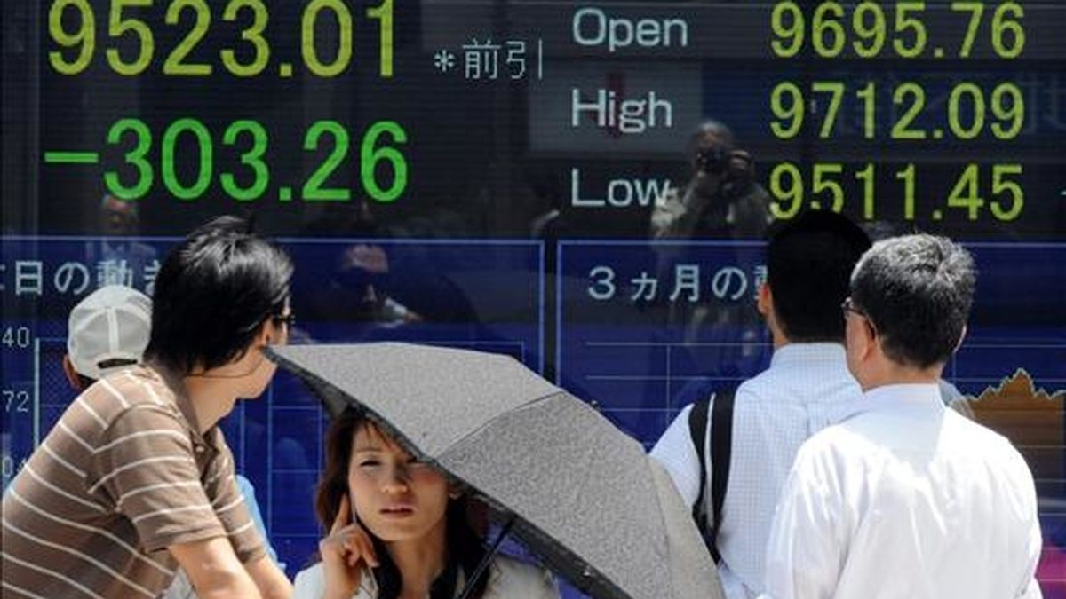 Transeúntes observan el tablero indicador del Nikkei en el centro de Tokio (Japón). EFE