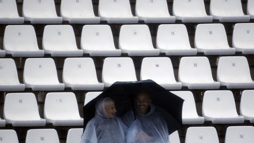 Dos espectadores se resguardan de la lluvia en Jerez