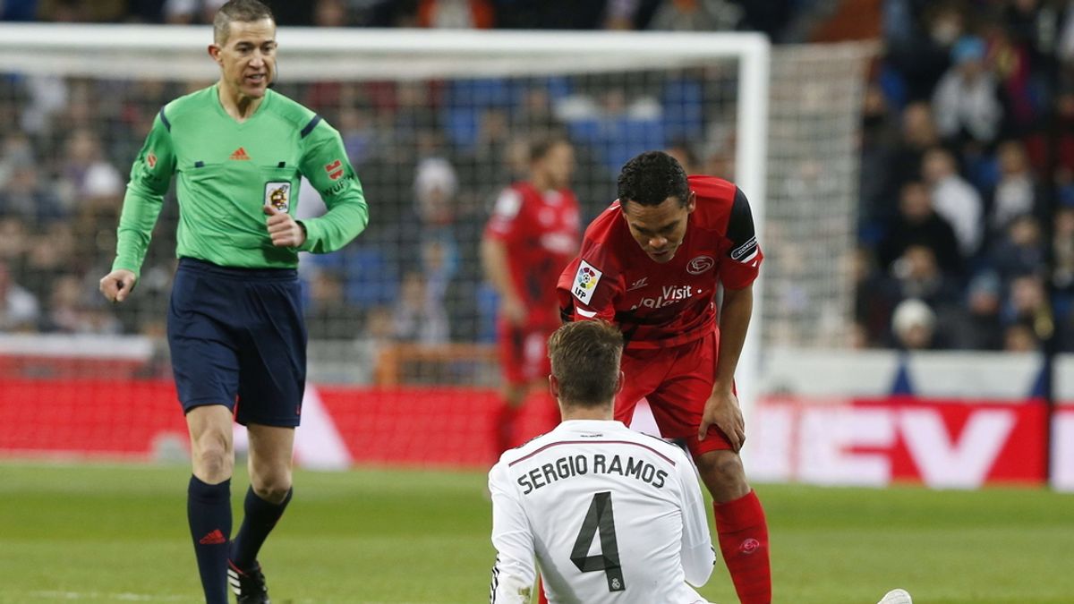 El defensa del Real Madrid Sergio Ramos (en el suelo) se lesiona durante el partido ante el Sevilla