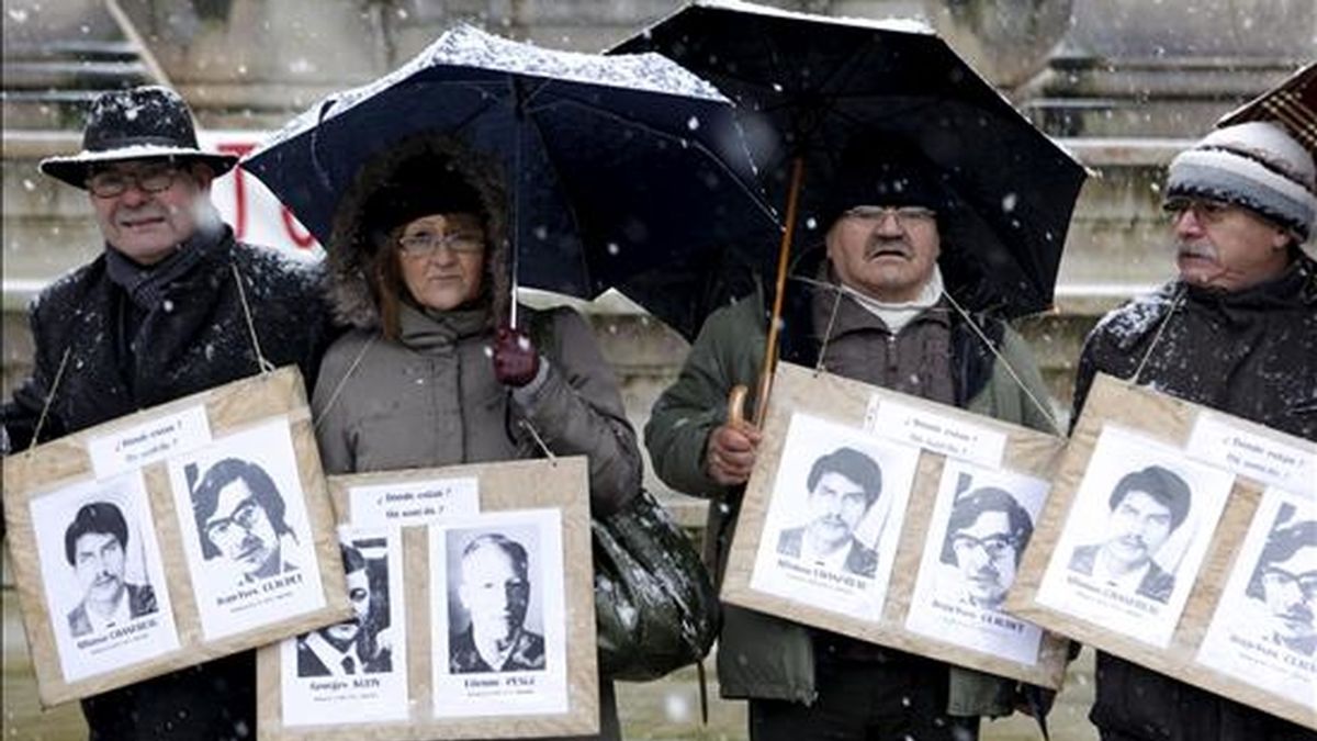 Familiares de víctimas de la dictadura chilena muestran fotos de sus seres queridos mientras participan en una manifestación en París (Francia). EFE