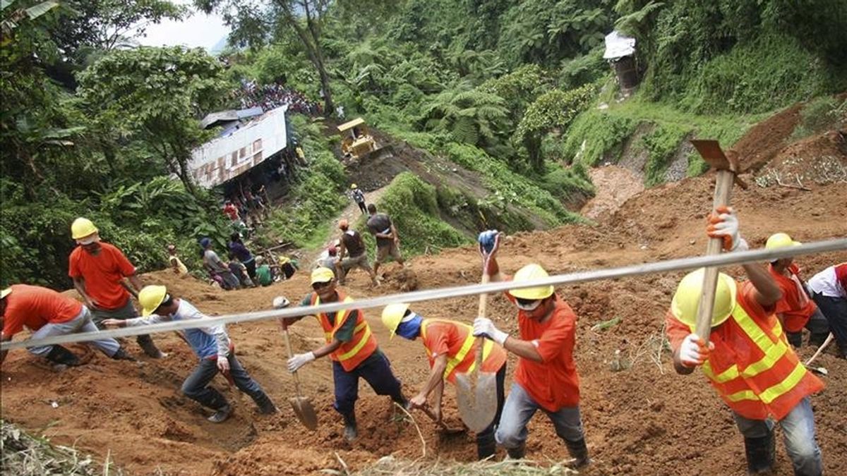 Voluntarios y miembros de los equipos de rescate reanudan la búsqueda de más de una veintena de personas, sepultadas 24 horas antes a causa de un alud de tierra, hoy en la localidad de Kingking, en la provincia de Valle Compostela, a 980 kilómetros al sur de Manila (Filipinas). EFE