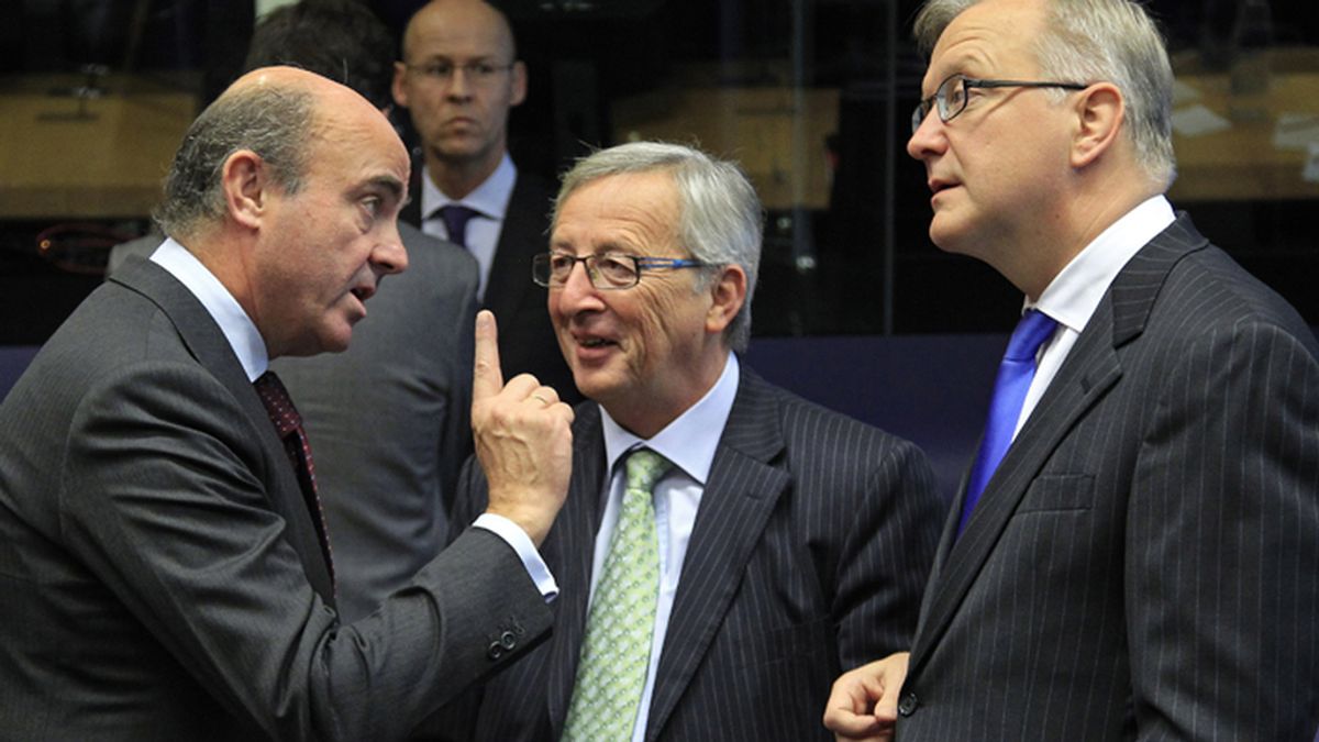 Luis de Guindos, conversa con Jean-Claude Juncker y Olli Rehn durante la reunión del Eurogrupo en Luxemburgo