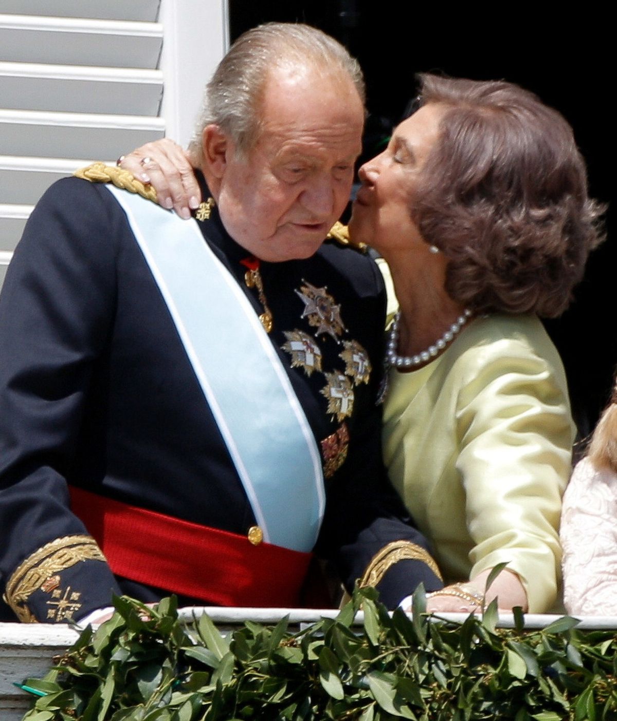 Don Juan Carlos recibe el beso cariñoso de doña Sofía en el balcón del Palacio Real