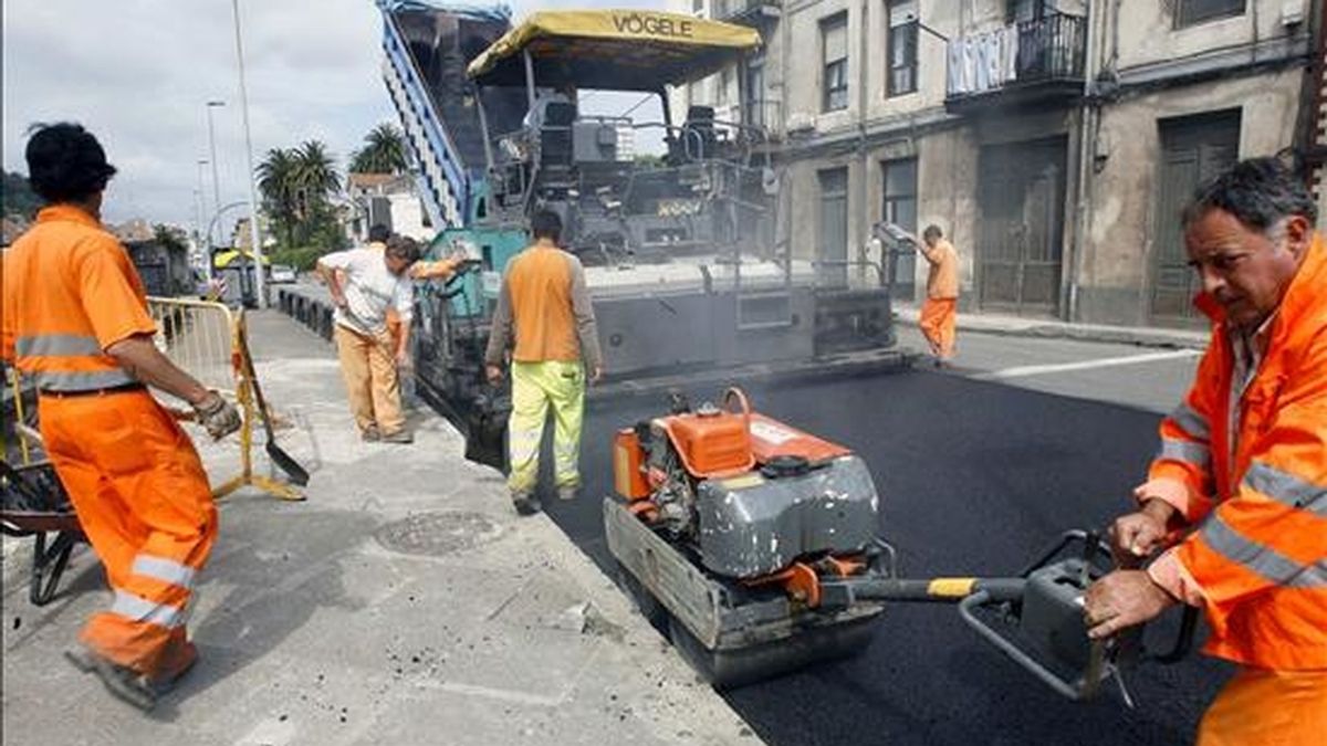 En la imagen, varios empleados asfaltan una calle en Santander. EFE/Archivo