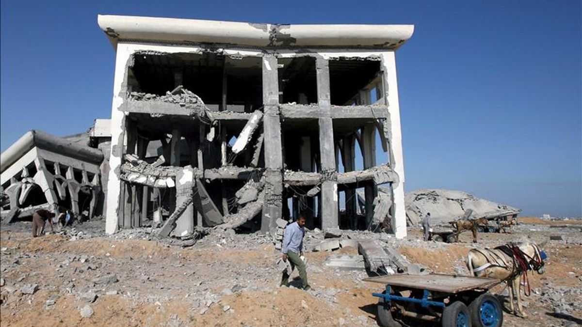 Un palestino trata de salvar unos bloques de cemento de las ruinas de un edificio destruido en un ataque aéreo israelí en el aeropuerto de Gaza, al sur de la Franja. EFE/Archivo