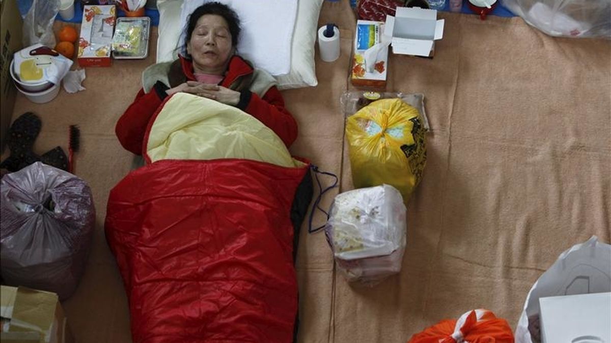 Una mujer descansa en una bolsa de dormir en un centro de evacuación, en la ciudad costera de Ishinomaki, que fue devastada por el tsunami del pasado 11 de marzo, en la provincia de Miyagi, al noreste de Japón. EFE